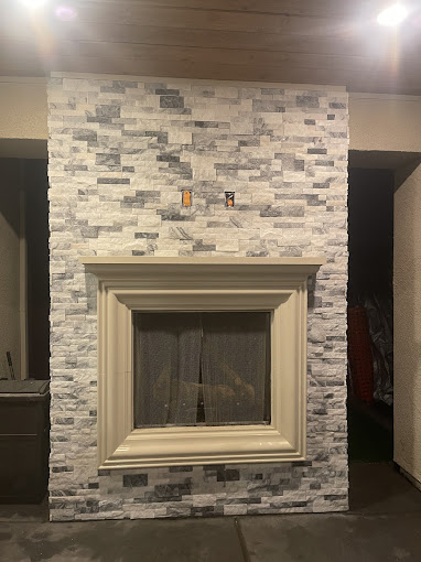 A white brick fireplace with a white mantle