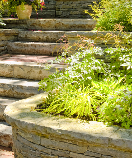 A stone wall with a planter on top of it