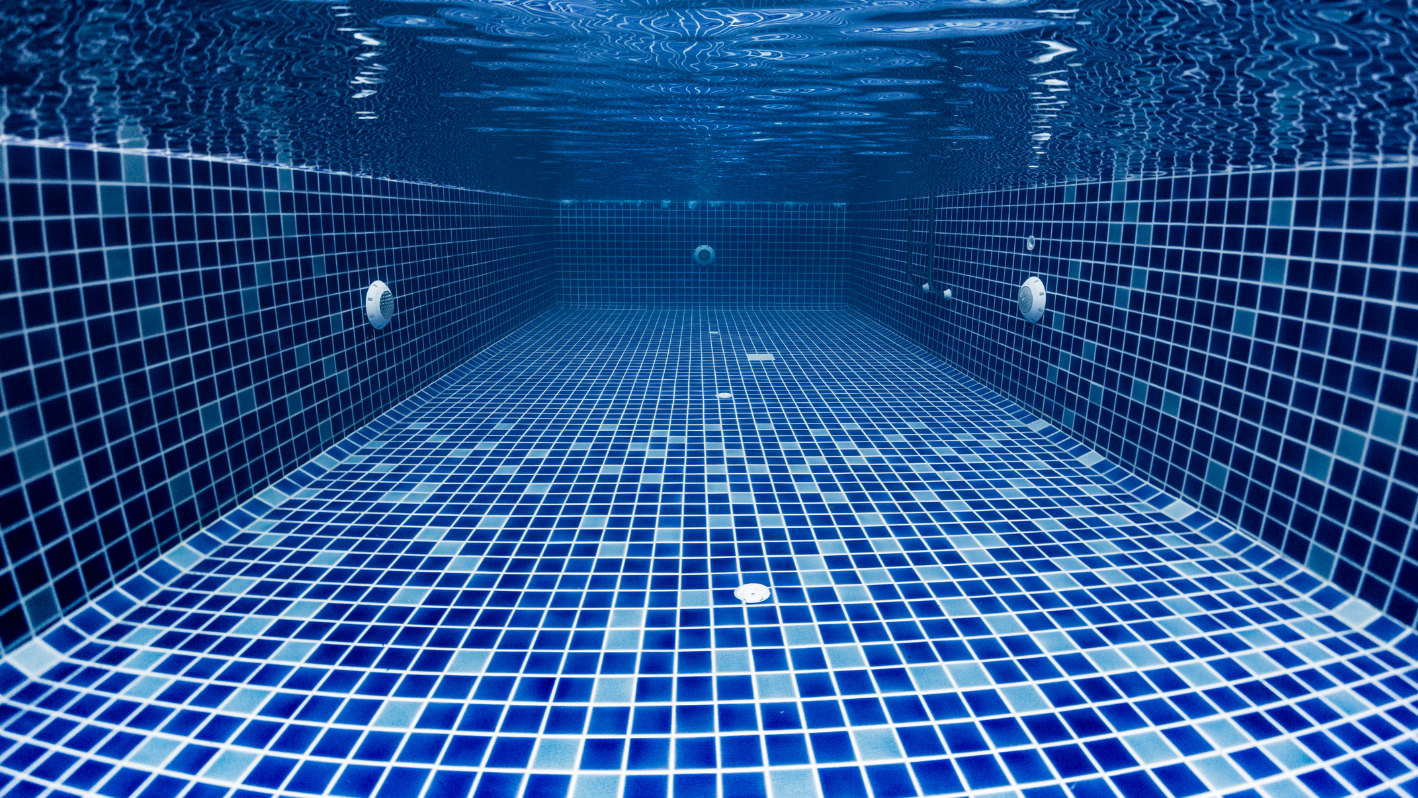 A blue tiled swimming pool with blue water